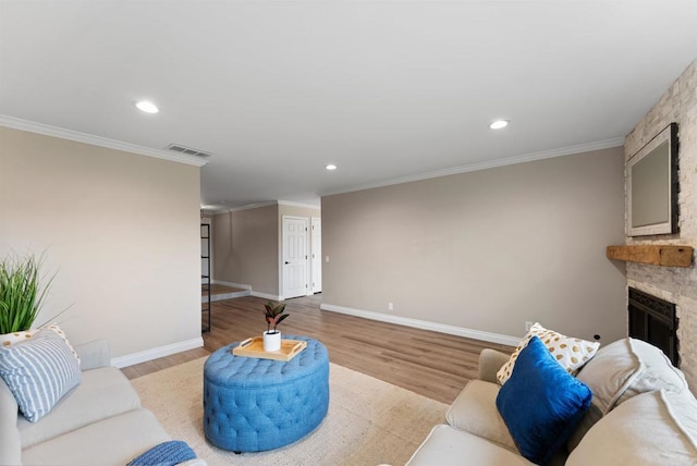 living room featuring a fireplace, ornamental molding, and light hardwood / wood-style flooring