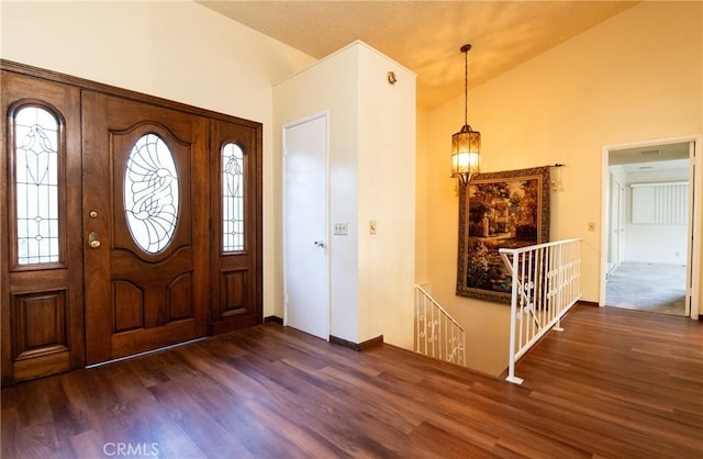 entrance foyer with vaulted ceiling and dark hardwood / wood-style flooring