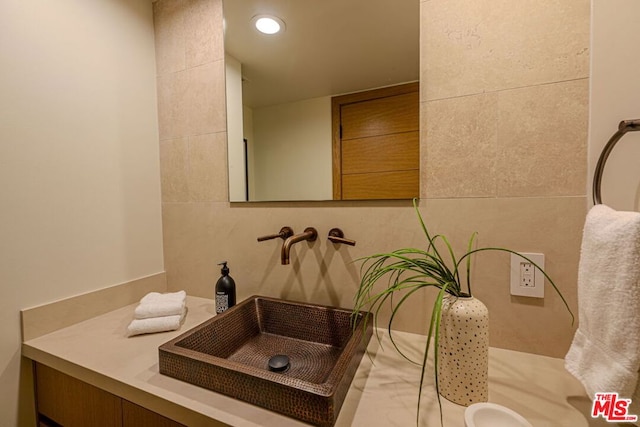 bathroom featuring tile walls and sink