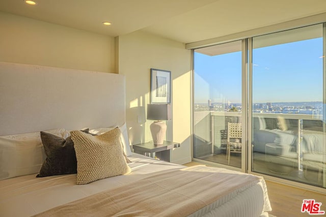 bedroom featuring expansive windows and light wood-type flooring