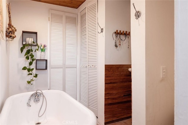 bathroom with a washtub and wood ceiling