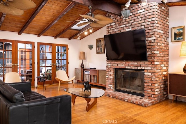 living room featuring ceiling fan, hardwood / wood-style floors, a fireplace, wooden ceiling, and french doors