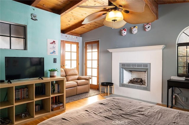 living room with a healthy amount of sunlight, vaulted ceiling with beams, wooden ceiling, and light hardwood / wood-style floors