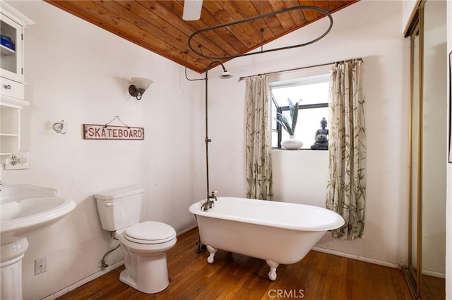 bathroom with vaulted ceiling, hardwood / wood-style floors, a bathtub, wood ceiling, and toilet