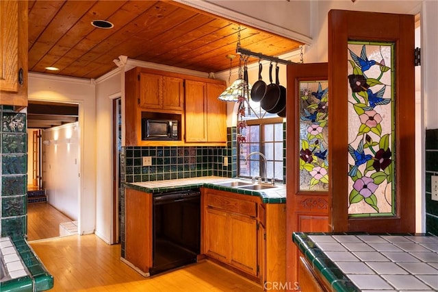 kitchen featuring sink, tile counters, and black appliances