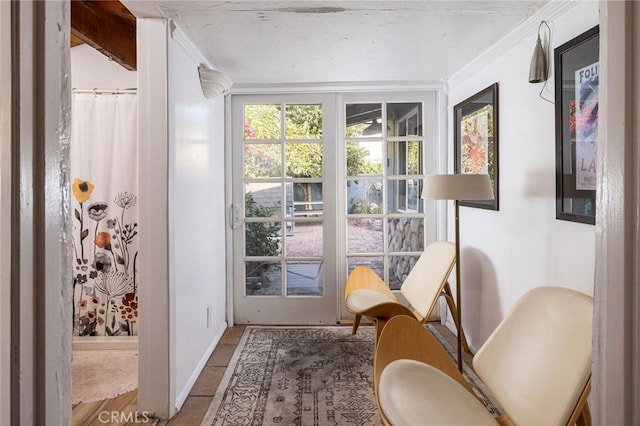 entryway with ornamental molding and tile patterned floors