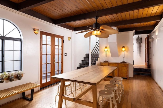 dining room featuring beamed ceiling, wood ceiling, french doors, and light wood-type flooring