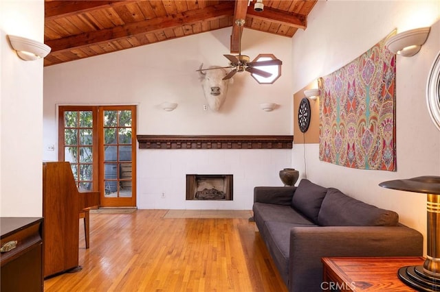 living room with vaulted ceiling with beams, wood ceiling, hardwood / wood-style floors, and ceiling fan