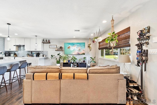 living room with a textured ceiling and dark hardwood / wood-style flooring