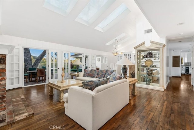 living room featuring built in shelves, lofted ceiling with skylight, dark hardwood / wood-style flooring, and french doors