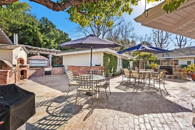 view of patio / terrace with a grill, an outdoor stone fireplace, and area for grilling