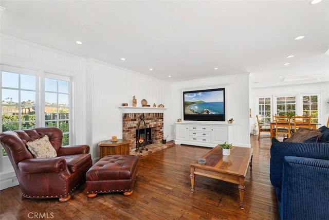 living room with dark hardwood / wood-style flooring, ornamental molding, and a fireplace