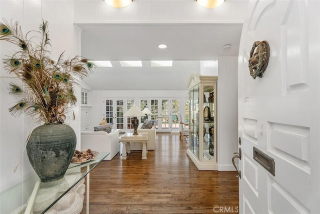 entrance foyer with vaulted ceiling, dark hardwood / wood-style flooring, and french doors