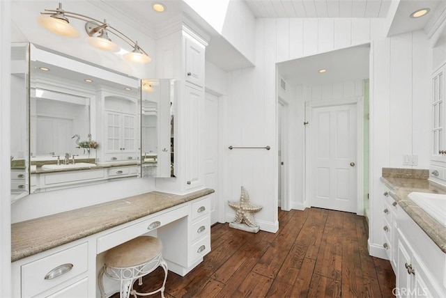 bathroom with wooden walls, lofted ceiling, wood-type flooring, and vanity