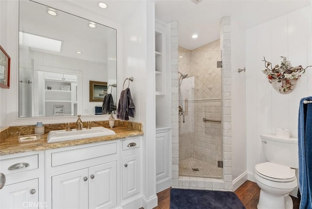 bathroom with vanity, toilet, wood-type flooring, and walk in shower