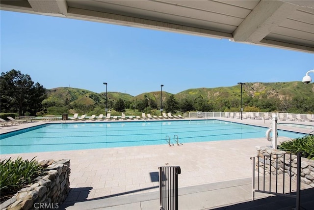 view of swimming pool featuring a mountain view and a patio