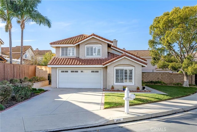 mediterranean / spanish-style house featuring a front yard and a garage