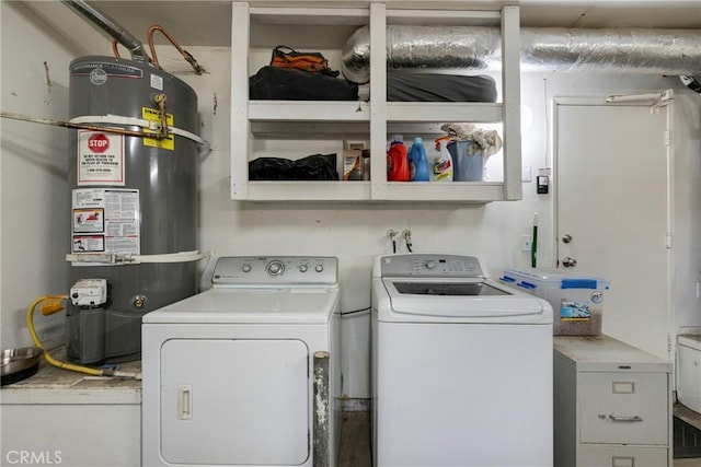 washroom with washing machine and clothes dryer and strapped water heater