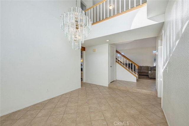 unfurnished room featuring light tile patterned floors, a towering ceiling, and a notable chandelier