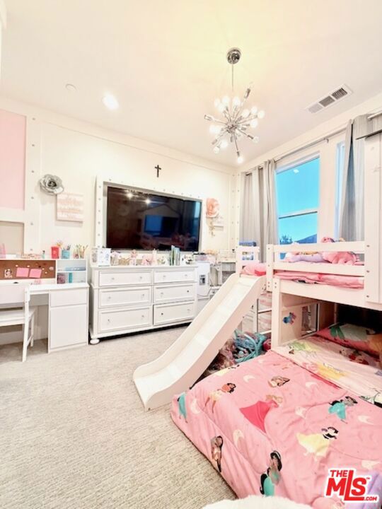 bedroom with ornamental molding, a notable chandelier, and carpet flooring