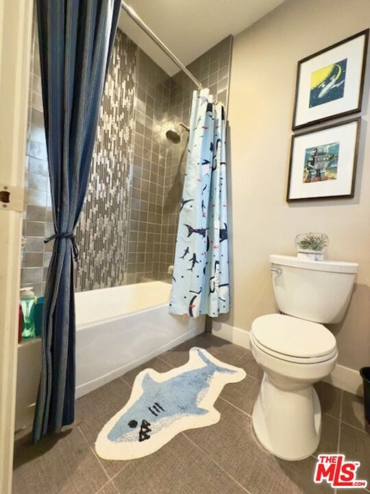 bathroom featuring toilet, tile patterned floors, and shower / bath combination with curtain