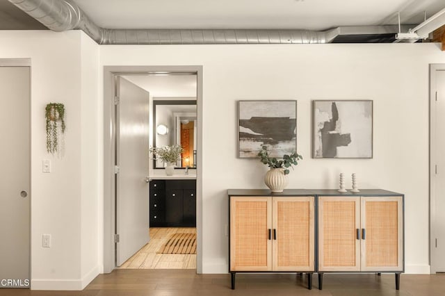 corridor with sink and hardwood / wood-style flooring