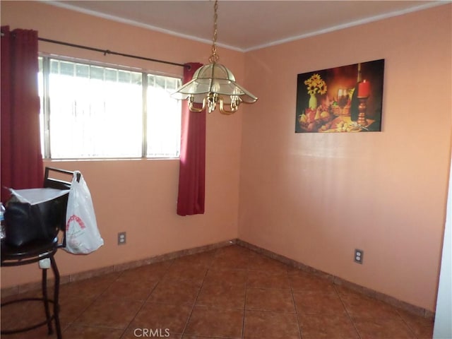 spare room with tile patterned floors and an inviting chandelier