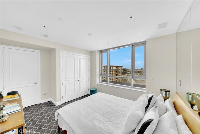 bedroom featuring baseboards, dark colored carpet, and a closet