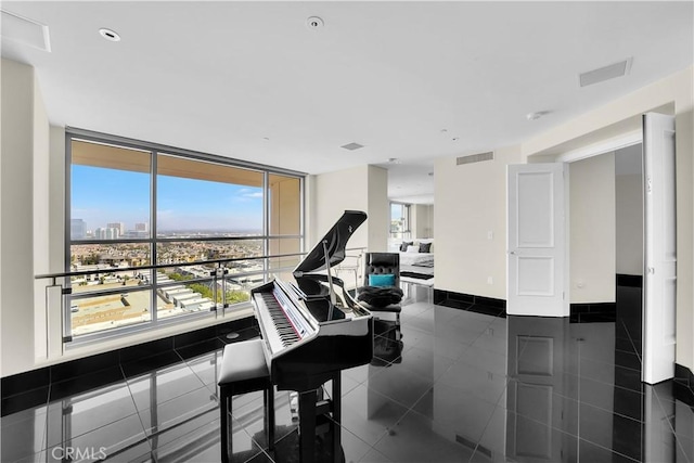 sitting room with granite finish floor, visible vents, a city view, and baseboards