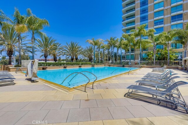 community pool with fence and a patio
