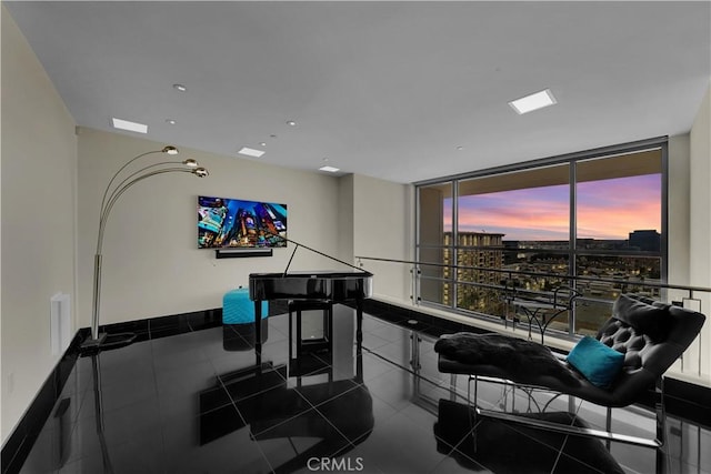 interior space with dark tile patterned floors, recessed lighting, and a wall of windows