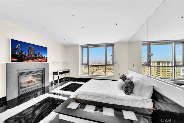 bedroom featuring a glass covered fireplace