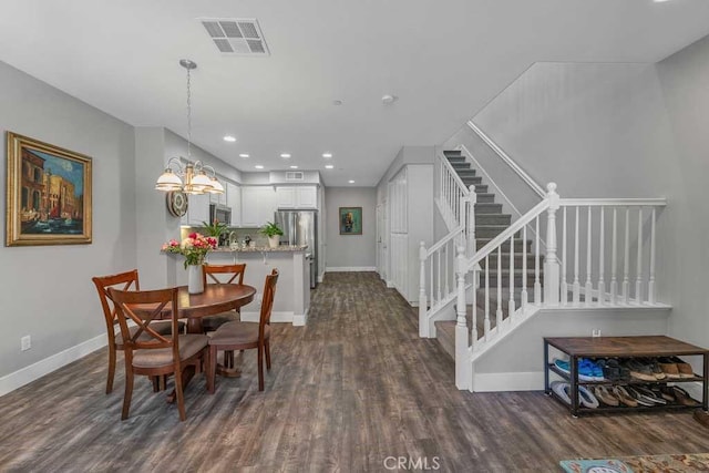 dining room with dark hardwood / wood-style flooring and a chandelier