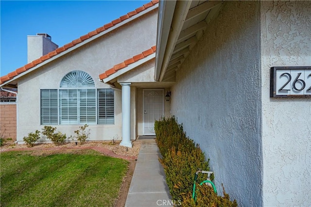 entrance to property featuring a lawn