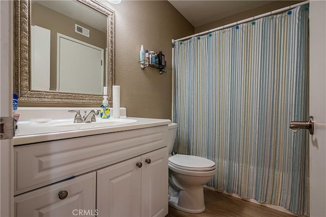 bathroom with toilet, vanity, a shower with shower curtain, and hardwood / wood-style flooring