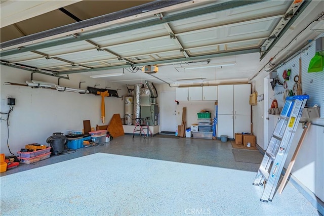 garage with heating unit, secured water heater, and a garage door opener