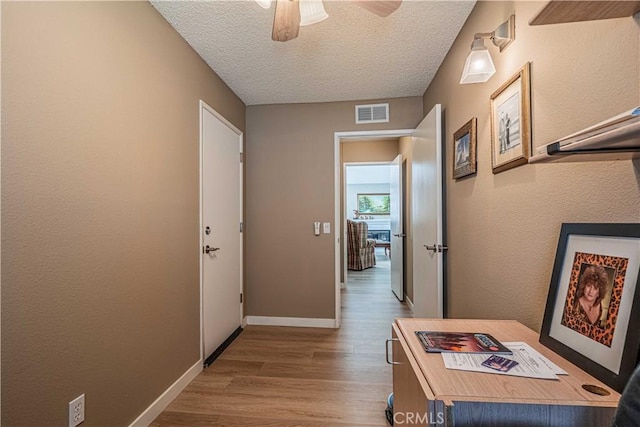 corridor featuring a textured ceiling and hardwood / wood-style flooring