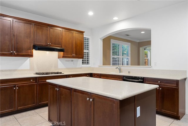 kitchen featuring light tile patterned floors, sink, crown molding, and a kitchen island