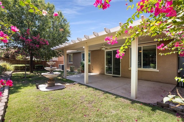 rear view of house featuring central AC unit, a yard, and a patio