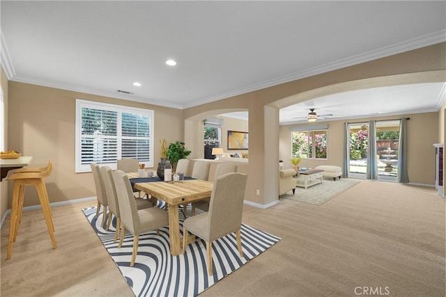 carpeted dining space featuring ceiling fan and ornamental molding