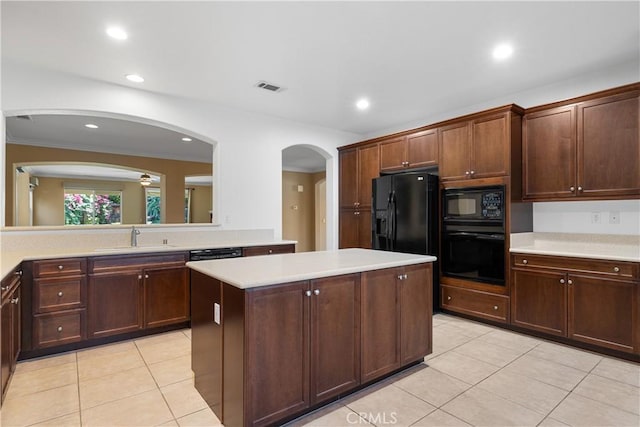 kitchen with ceiling fan, a center island, light tile patterned flooring, black appliances, and sink