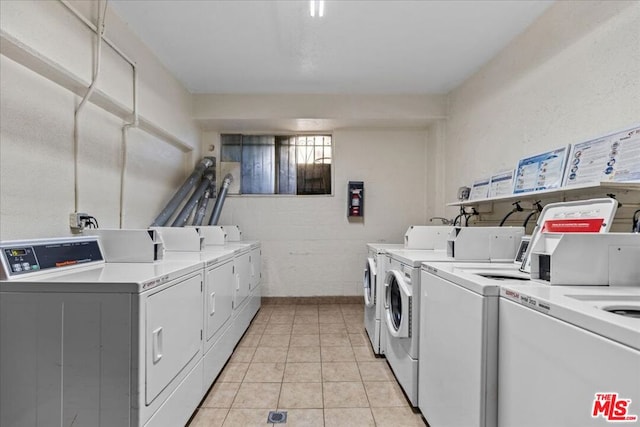 clothes washing area with light tile patterned floors and independent washer and dryer