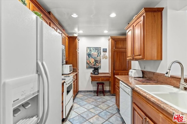 kitchen with light tile patterned floors, sink, light stone counters, and white appliances