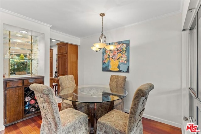 dining space with an inviting chandelier, crown molding, and hardwood / wood-style floors