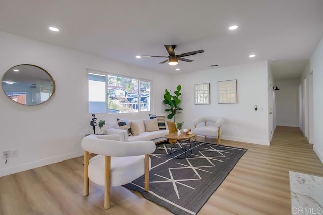 living room with ceiling fan and light hardwood / wood-style flooring