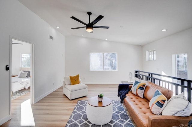 living room with ceiling fan, lofted ceiling, and light wood-type flooring