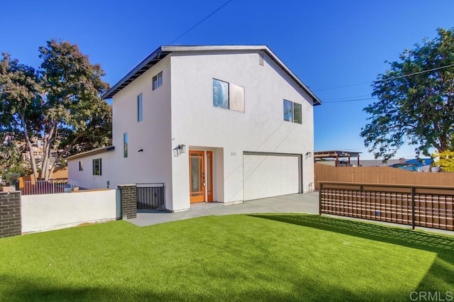 back of house with a garage and a lawn