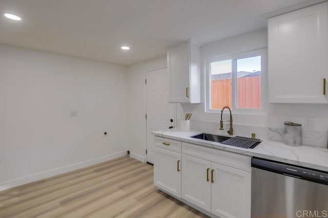 kitchen featuring light wood-type flooring, dishwasher, light stone countertops, white cabinets, and sink