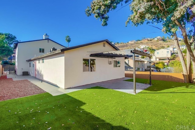 rear view of property with a yard, a pergola, and a patio