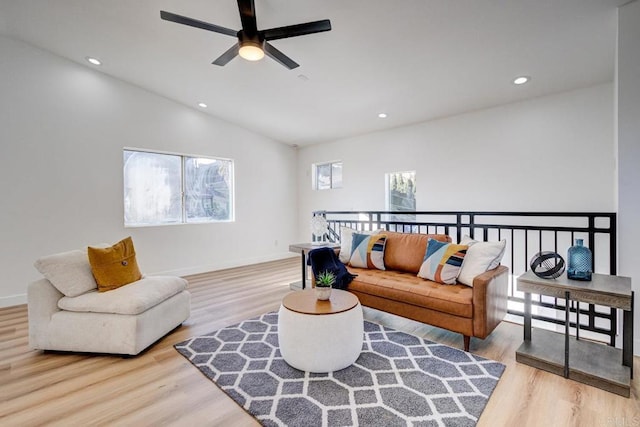 living room featuring ceiling fan, light hardwood / wood-style floors, plenty of natural light, and vaulted ceiling